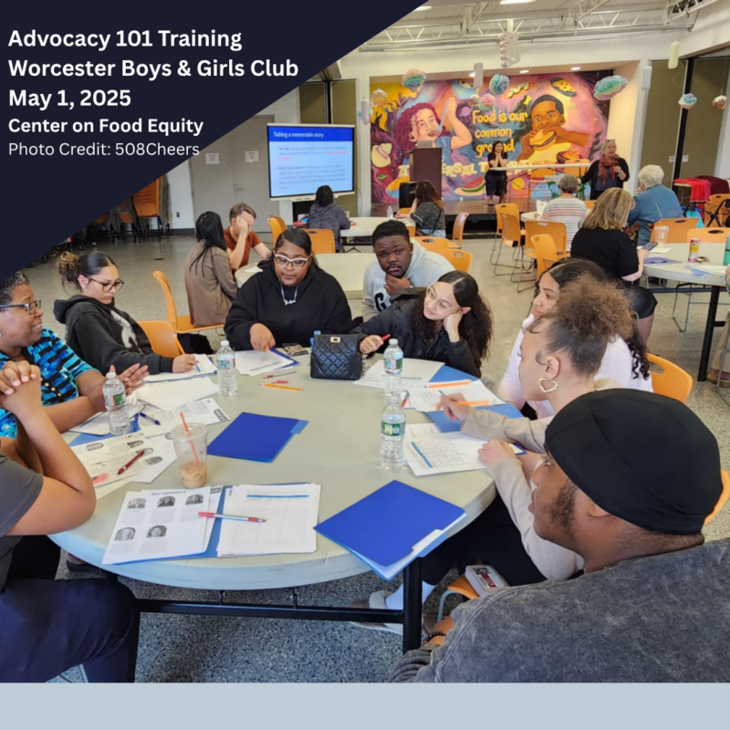 A photo from a Center on Food Equity event, showing speakers at the front of a gymnasium, and several tables of people engaged in conversation.